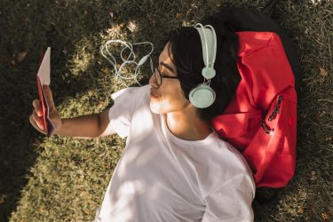 etnica-adolescente-deitado-no-chao-com-o-livro